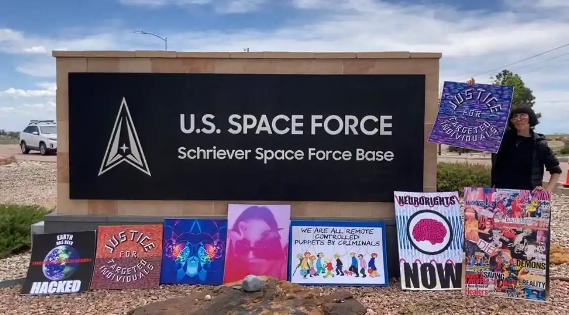 Photograph of small collage panels propped in a row beneath a U.S. Space Force base sign.